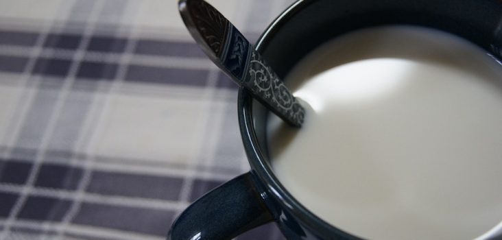 Tasse auf Tischdecke mit Milch