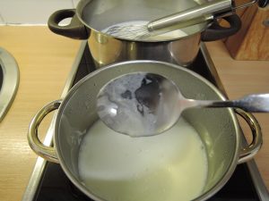 Milchhaut auf Löffel von Rohmilch