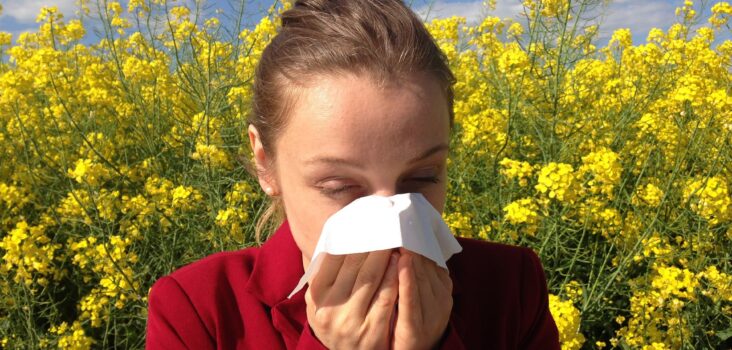 Person mit Pollenallergie schnäuzt sich