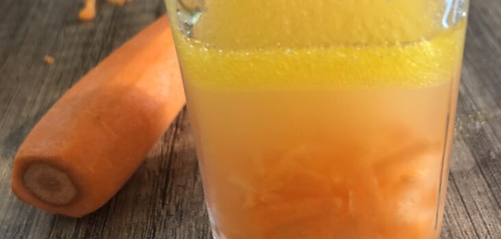 Karotten und Flüssigkeit mit orangem Farbstoff